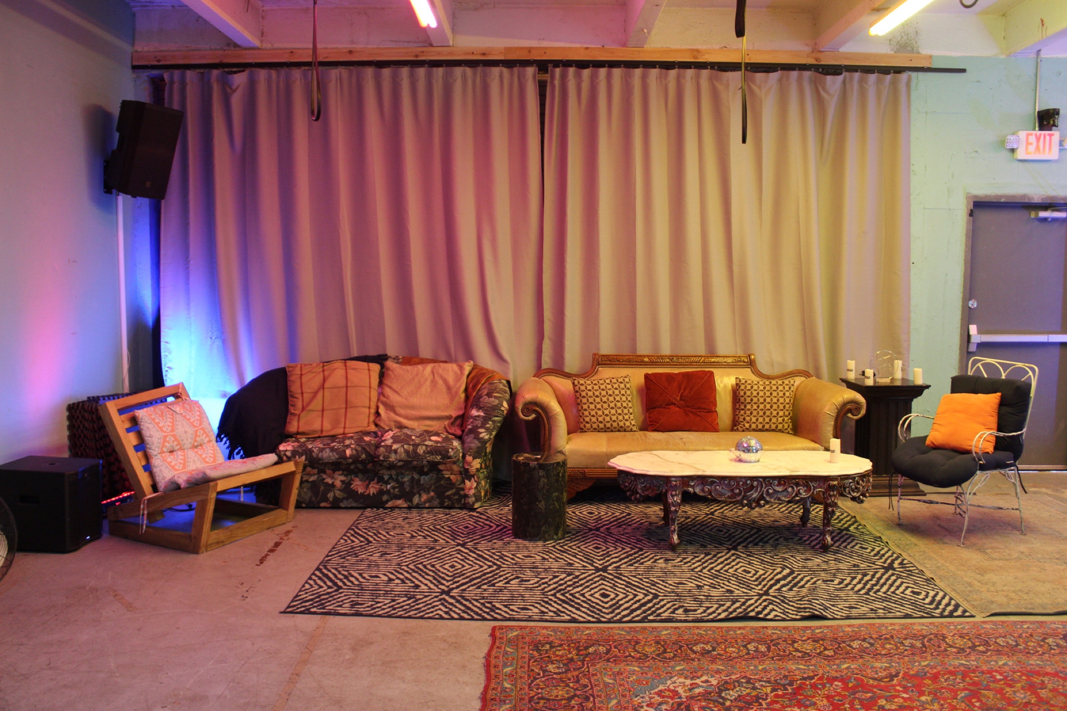 The Dear Eleanor lounge area with sofas, rugs, and soft colorful lighting
